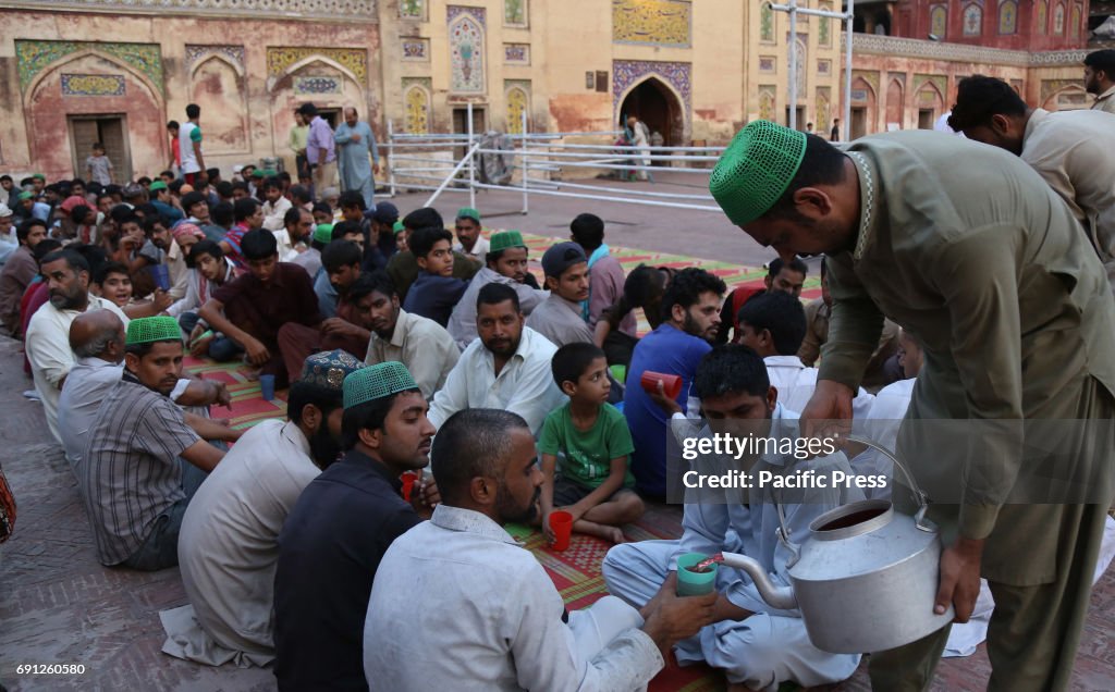 Pakistani volunteers distributing Iftar foods before...