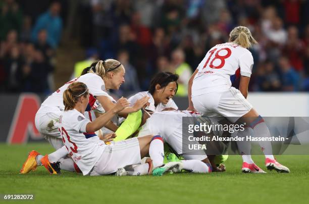 Sarah Bouhaddi of Olympique Lyonnais celebrates victory with team mates as she scores the winning penalty in the shoot out during the UEFA Women's...