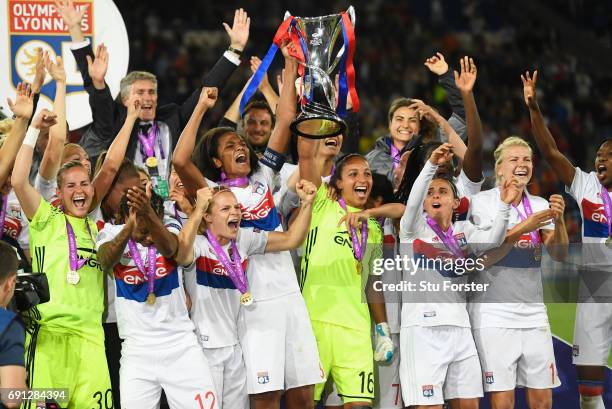 Wendie Renard and Sarah Bouhaddi of Olympique Lyonnais lift the trophy in victory after the UEFA Women's Champions League Final between Lyon and...