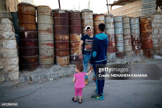 Photo taken on May 29, 2017 shows Palestinians walking next to an army barrier near the Tomb of the Patriarchs, known in Arabic as the Ibrahimi...