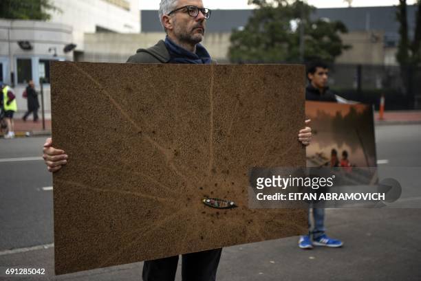 Greenpeace activists demonstrate outside the United States embassy in Buenos Aires, Argentina, on June 1 against US President Donald Trump's decision...