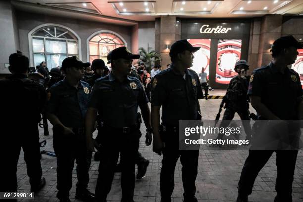 Policemen secure the entrance of Resorts World Manila after a shooting incident inside the entertainment resort in Pasay City on June 2, 2017 in...