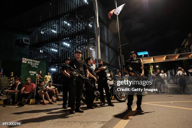 Filipino policemen stand guard outside the Resorts World Manila building after gunshots and explosions were heard in Pasay City on June 2, 2017 in...