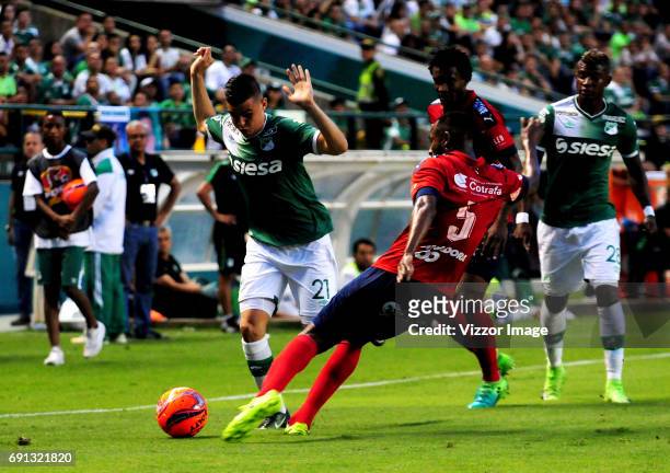 Nicolas Benedetti of Deportivo Cali competes for the ball with Juan David Valencia of Independiente Medellin duing a match between Deportivo Cali and...