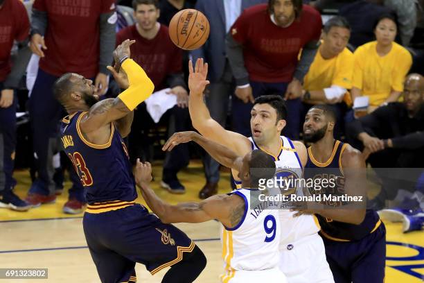 LeBron James of the Cleveland Cavaliers goes up for a shot against Zaza Pachulia and Andre Iguodala of the Golden State Warriors in Game 1 of the...