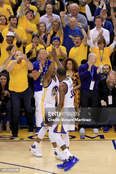 Andre Iguodala and Kevin Durant of the Golden State Warriors celebrate after a 3-point pasket by Iguodala against the Cleveland Cavaliers in Game 1...