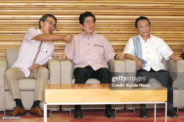 Economic and Fiscal Policy Minister Nobuteru Ishihara, Prime Minister Shinzo Abe and Finance Minister Taro Aso attend a Cabinet meeting at the prime...