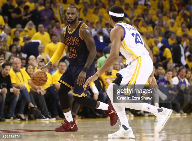 LeBron James of the Cleveland Cavaliers is defended by James Michael McAdoo of the Golden State Warriors during the first half of Game 1 of the 2017...