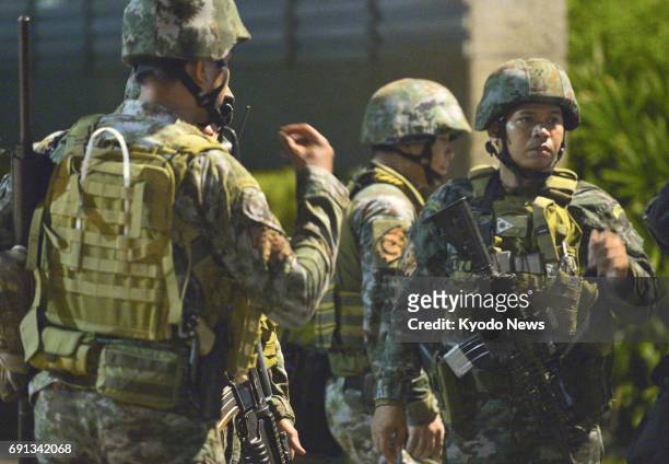 Members of a special police unit stand guard around the Resorts World Manila hotel and casino in the Philippines capital in the early hours of June...