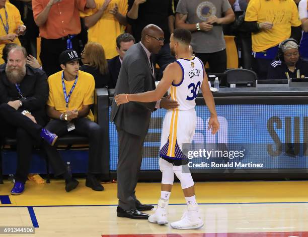 Mike Brown speaks with Stephen Curry of the Golden State Warriors against the Cleveland Cavaliers during the second half of Game 1 of the 2017 NBA...