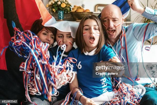 french cheering family watching soccer match on smartphone at home - football phone stock pictures, royalty-free photos & images