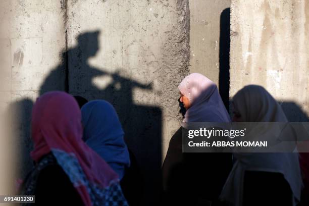 Palestinians wait to cross the Qalandia checkpoint between the West Bank city of Ramallah and Jerusalem as they head to Jerusalem's Al-Aqsa Mosque...