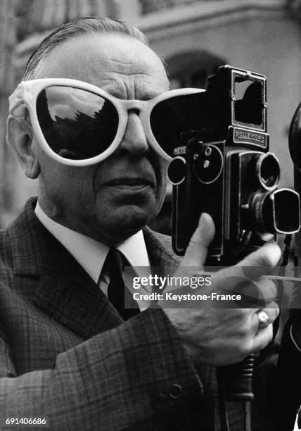 Ce touriste chasseur d'images s'est muni d'une paire de lunettes noires géantes pour ne pas être gêné par le soleil, à Paris, France le 21 juillet...