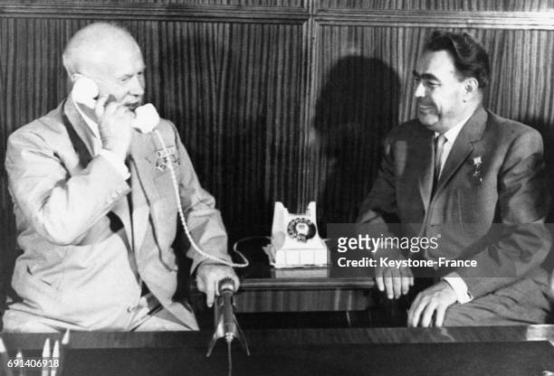 Nikita Khrouchtchev et Leonid Brejnev au téléphone avec les astronautes Andrian Nikolaev et Pavel Popovich afin de les féliciter de leur voyage de...
