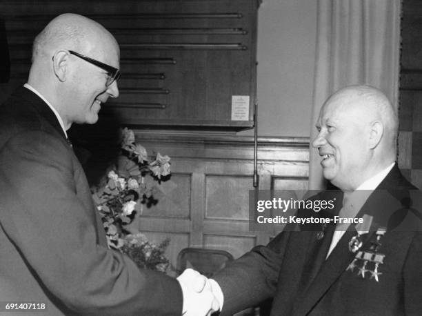 Le président finlandais Urho Kekkonen serre la main à Nikita Khrouchtchev pour lui souhaiter son 70 ème anniversaire le 17 avril 1964 à Moscou,...