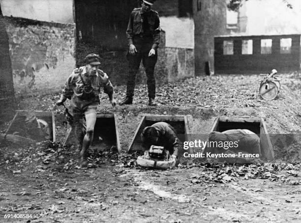 Trois garçons des Jeunesses hitlériennes sortent en rampant d'un tunnel lors d'un événement sportif à Prenzlauer Berg, circa 1930 à Berlin, Allemagne.