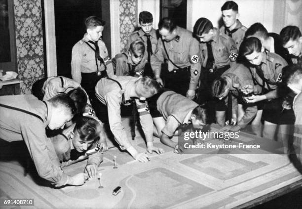 Les garçons des Jeunesses Hitlériennes s'initient aux dangers de la circulation routière grâce à une maquette le 9 octobre 1937 en Allemagne.