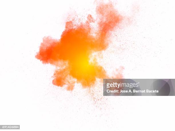 forms and textures of an explosion of a powder of colors yellow and orange  on a  white bottom - orange powder ストックフォトと画像
