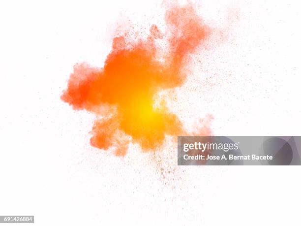 forms and textures of an explosion of a powder of colors yellow and orange  on a  white bottom - fireworks on white stockfoto's en -beelden