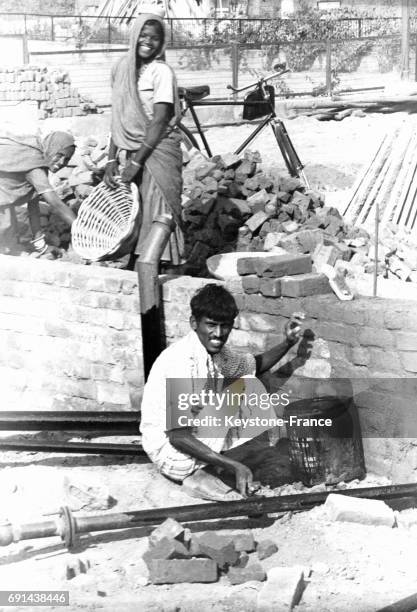 Des hommes et femmes pauvres travaillent comme petite main d'oeuvre sur un chantier de constrution, à New Delhi, Inde.