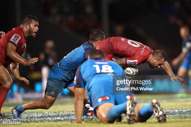Quade Cooper of the Reds is tackled during the round 15 Super Rugby match between the Blues and the Reds at Apia Park National Stadium on June 2,...