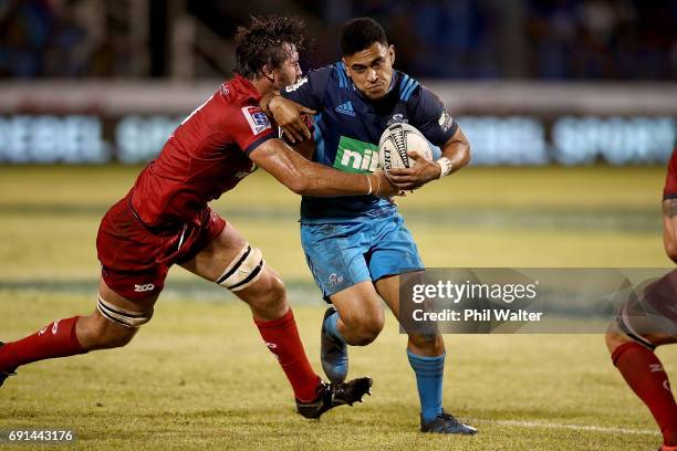 Stephen Perofeta of the Blues is tackled during the round 15 Super Rugby match between the Blues and the Reds at Apia Park National Stadium on June...
