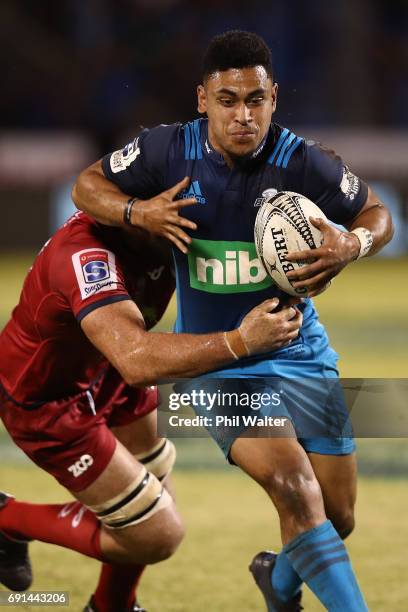 Stephen Perofeta of the Blues is tackled during the round 15 Super Rugby match between the Blues and the Reds at Apia Park National Stadium on June...