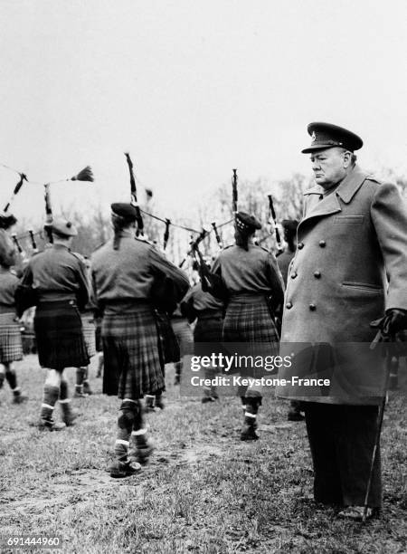 Winston Churchill regardant défiler la 51e Division des Ecossais jouant de la cornemuse, au Royaume-Uni en 1946.