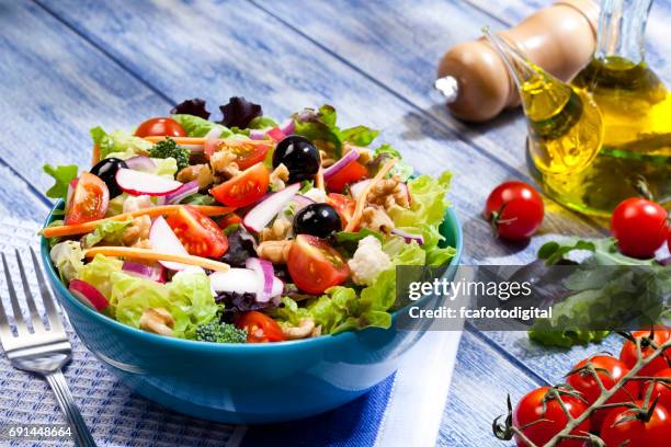 frisse salade plate op blauwe picknicktafel - olive fruit stockfoto's en -beelden