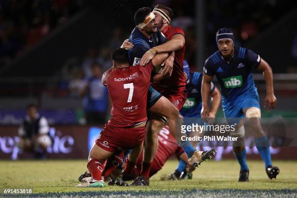 Alex Hodgman of the Blues is tackled during the round 15 Super Rugby match between the Blues and the Reds at Apia Park National Stadium on June 2,...