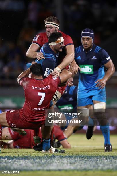 Alex Hodgman of the Blues is tackled during the round 15 Super Rugby match between the Blues and the Reds at Apia Park National Stadium on June 2,...