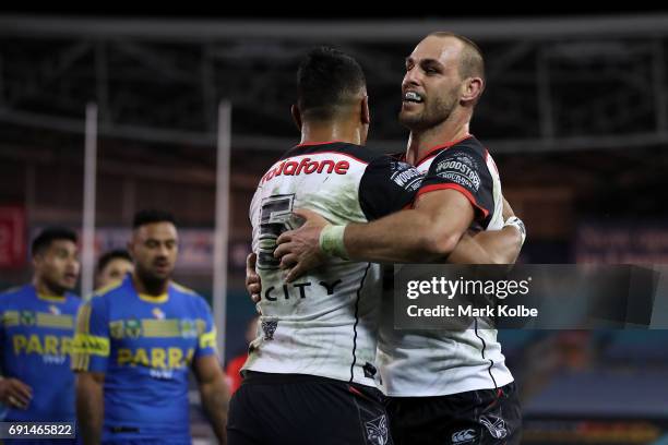 Ken Maumalo of the Warriors celebrates with his team mate Simon Mannering of the Warriors after scoring a try during the round 13 NRL match between...