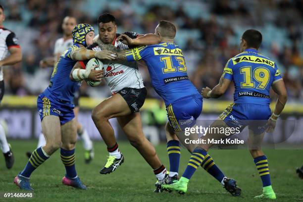 Sam Lisone of the Warriors is tackled by Beau Scott and Nathan Brown of the Eels during the round 13 NRL match between the Parramatta Eels and the...