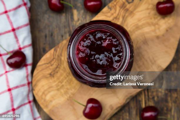 jar of homemade cherry jam and cherries on wood - larissa veronesi bildbanksfoton och bilder