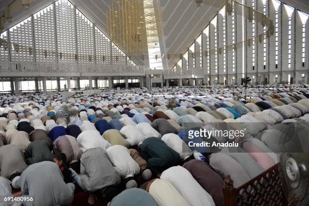 Pakistani Muslims perform the first Friday Prayer during Islam's holy fasting month of Ramadan at Turkish-designed Faisal Mosque in Islamabad,...