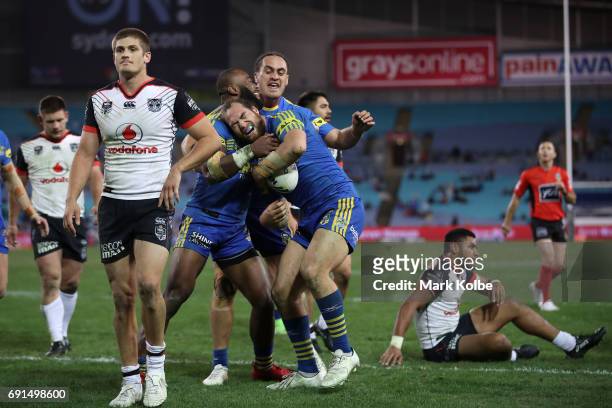 Blake Ayshford of the Warriors looks dejected as Tepai Moeroa of the Eels celebrates with his team mates after scoring a try during the round 13 NRL...