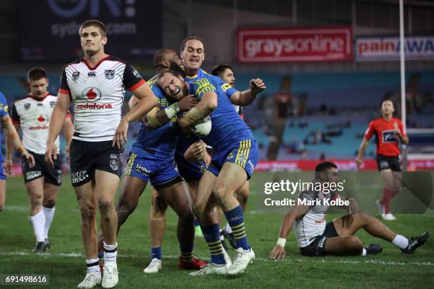 Blake Ayshford of the Warriors looks dejected as Tepai Moeroa of the Eels celebrates with his team mates after scoring a try during the round 13 NRL...