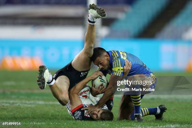 Blake Ayshford of the Warriors falls as he tackles Bevan French of the Eels during the round 13 NRL match between the Parramatta Eels and the New...