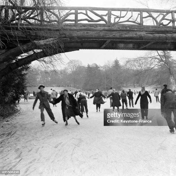 Patineurs sur le lac gelé du Bois de Boulogne à Paris, France en février 1954.