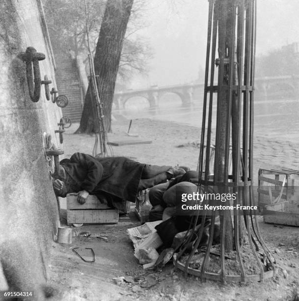 Clochard dormant sur les quai de Seine à Paris, France en 1954.