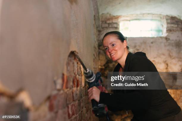 woman removing old mortar. - casser mur photos et images de collection