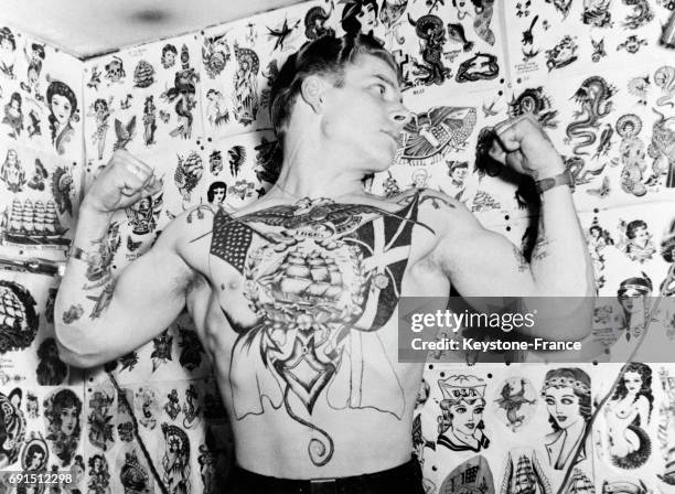 Homme torse nu montrant son tatouage, au Danemark en 1952.