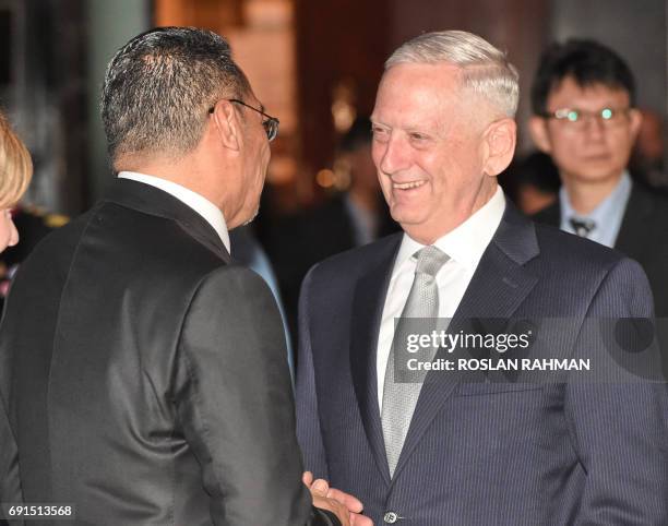 Pentagon chief Jim Mattis speaks with Malaysia's Defence Minister Hishammuddin Tun Hussein at the opening dinner of the Institute for Strategic...