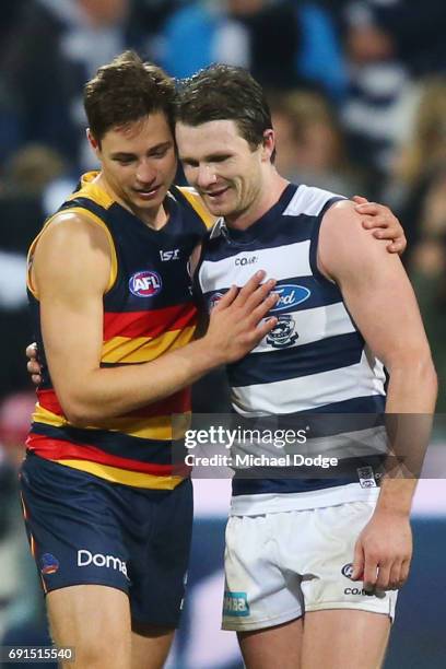 Patrick Dangerfield of the Cats celebrates the win when catching up with former teammate Jake Lever of the Crows during the round 11 AFL match...