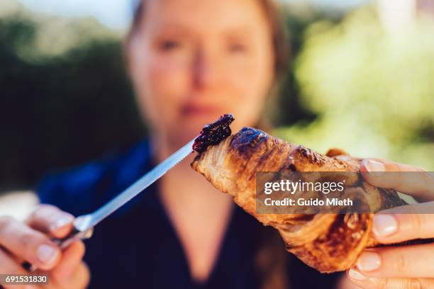 woman eating a croissant. - croissant jam stock pictures, royalty-free photos & images