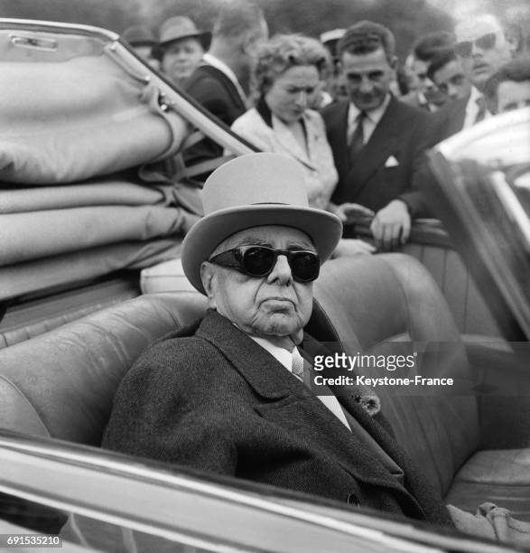 Le prince Aga Khan III venu assister, depuis sa voiture, au Prix de Diane où certains de ses chevaux couraient, à Chantilly, France, le 9 juin 1957.