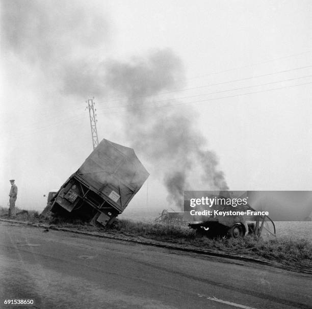 Photographie de l'accident survenu sur la route Paris-Lille où un peugeot 203 voulant éviter un cycliste a dérapé sur le sol mouillé, a heurté un...