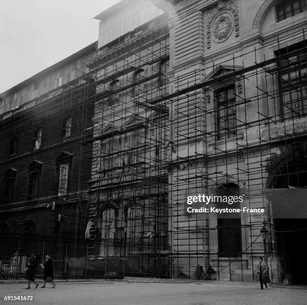 Ravalement d'une des façades du musée du Louvre donnant sur la rue de Rivoli à Paris, France, le 21 novembre 1964.