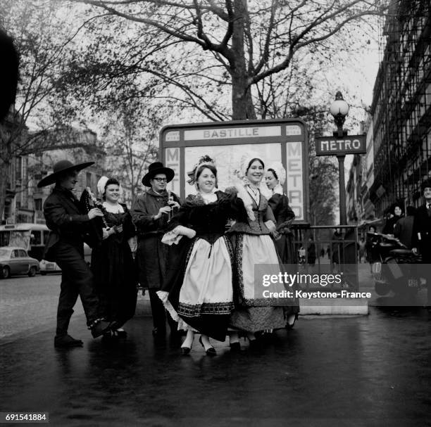 Groupe folklorique dansant la bourrée lors de la semaine auvergnate à la la Bastille à Paris, France, le 8 décembre 1964.