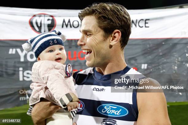 Tom Hawkins of the Cats runs onto the field for his 200th match with daughter Arabella during the 2017 AFL round 11 match between the Geelong Cats...